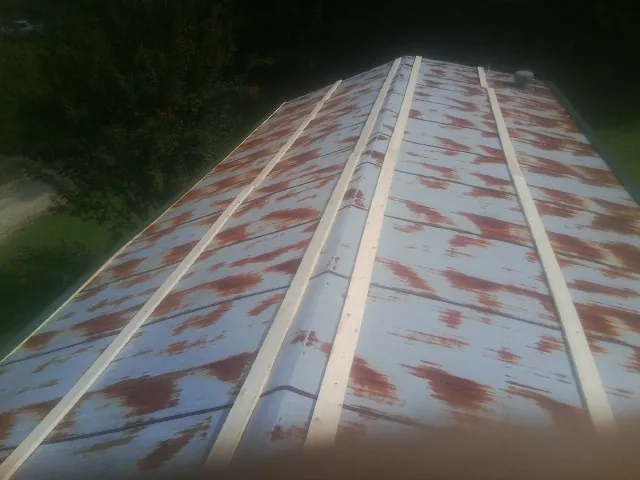 Rusted metal roof panels with new wood purlins before replacement — Storm Damage Roof Repair in Bryantown by Roofing Brothers