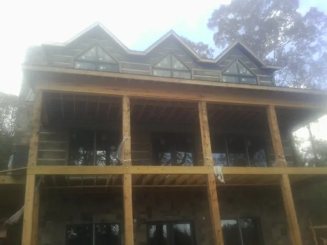 Dormers and porch framing on a large log home under construction — Roof Coating work by our crew in Bryantown