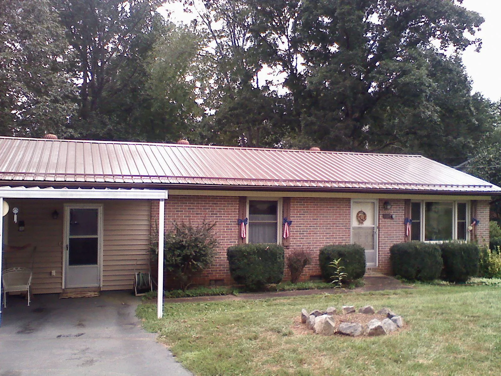 Bronze metal roof and carport on a brick ranch home — Roof Repair work by our crew in Bryantown