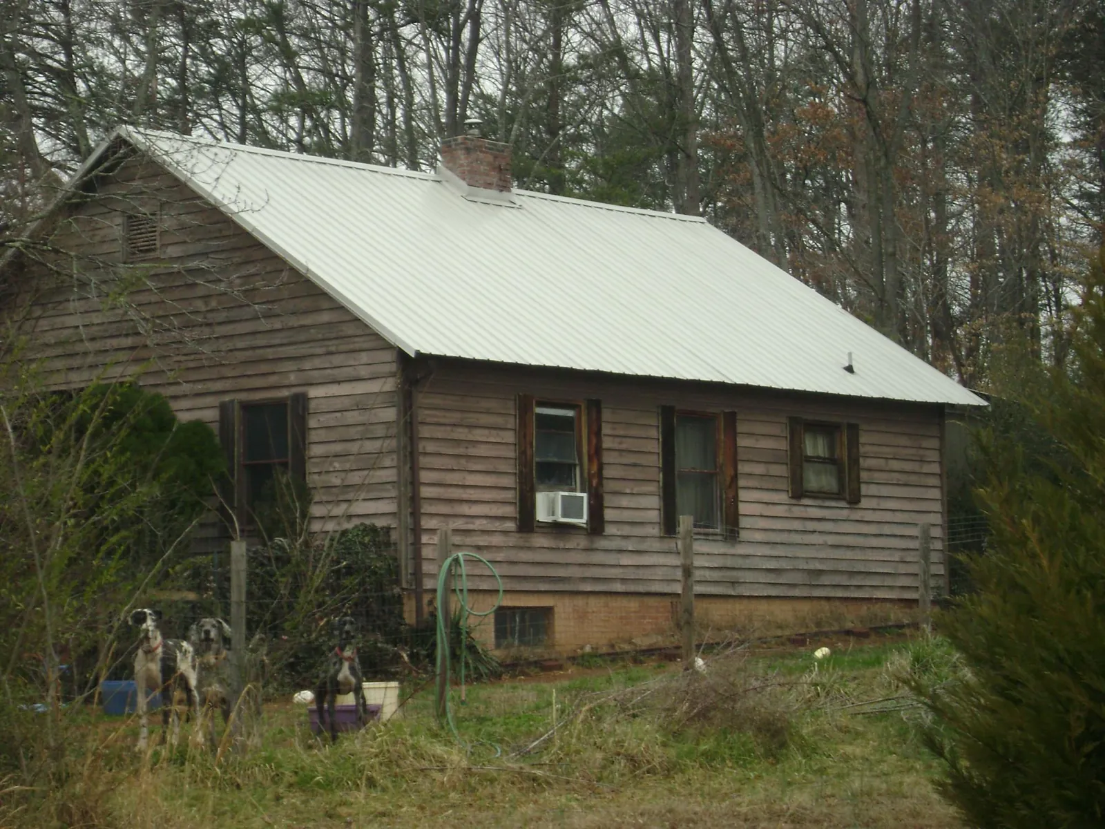 White metal roof on an old wood sided farmhouse, from a Metal Roof Installation job in Bryantown